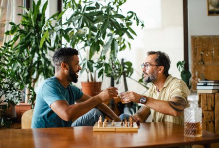 Beste Freunde, die zusammen Schach spielen, Whisky trinken und reden. Konzept der Männerfreundschaft und -bromance.