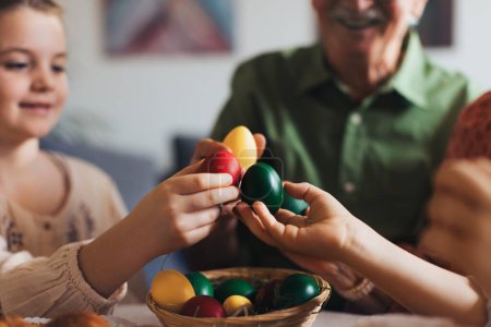 Photo for Grandparents and girl holding decorated easter eggs. Tradition of painting eggs with brush and easter egg dye. Concept of family easter holidays. - Royalty Free Image