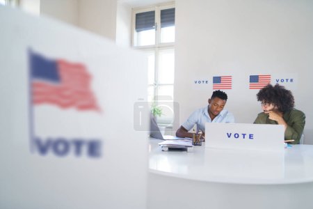 Téléchargez les photos : Deux membres de la commission électorale dans le bureau de vote le jour du scrutin, les élections américaines. - en image libre de droit