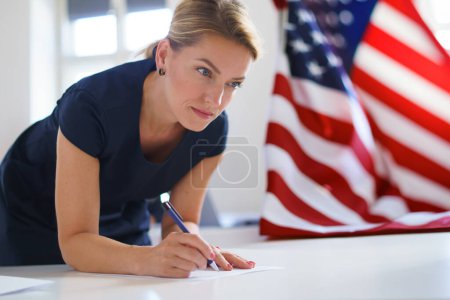 Votante femenina llenando papeleta electoral. Ciudadano estadounidense votando en un lugar de votación el día de las elecciones, EE.UU. elecciones.