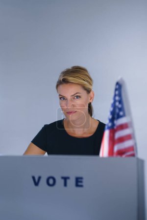 Retrato de votante femenina llenando papeleta electoral. Ciudadano estadounidense votando en un lugar de votación el día de las elecciones, EE.UU. elecciones.