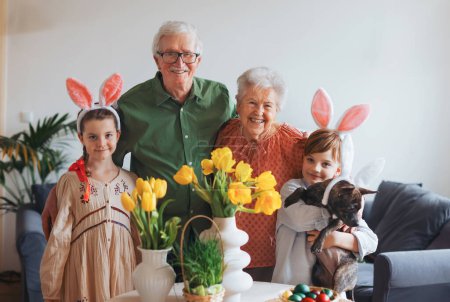 Photo for Easter portriat of grandparents with grandchildren before traditional easter lunch. Recreating family traditions and customs. Concept of family easter holidays. - Royalty Free Image