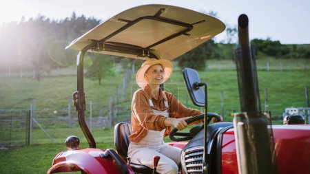 Progressive Bäuerin mit Traktor auf ihrem eigenen Hof. Frauenbild in der Landwirtschaft.