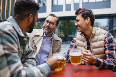 Meilleurs amis togehter, boire de la bière dans le bar de la ville et parler, s'amuser et rire. Concept d'amitié masculine, bromance.