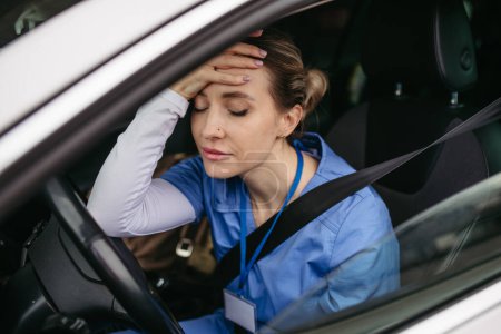 Enfermera llorando en coche, volviendo a casa después de un duro día de trabajo en el hospital. Doctor sintiéndose exhausto, frustrado, triste y enojado. Equilibrio entre vida laboral y personal sanitario.