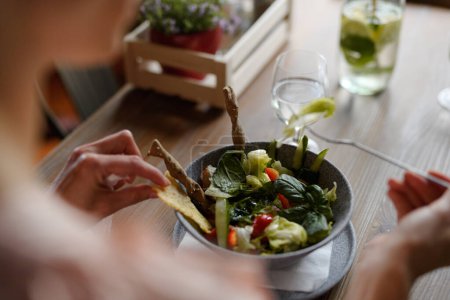 Téléchargez les photos : Gros plan de la salade de légumes servant au restaurant, client mangeant des aliments sains à partir du bol de porcelaine. - en image libre de droit