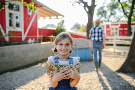 Photo for Beautiful young girl helping on family farm during summer, holding lavender plant in pot. . Future female farmer. - Royalty Free Image