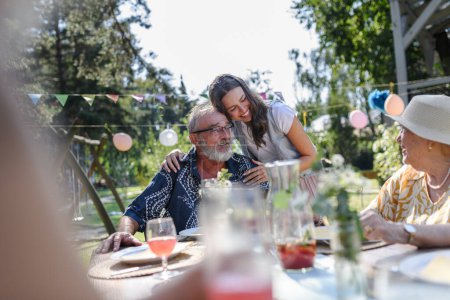 Foto de Nieta madura hablando con los abuelos, reunirse después de mucho tiempo. Reunión familiar en una fiesta en el jardín. - Imagen libre de derechos