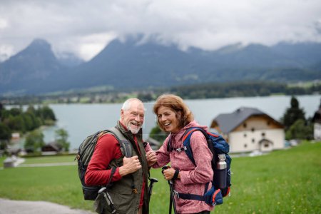 Foto de Pareja de ancianos activos caminando juntos en las montañas de otoño. Turistas mayores disfrutando de la naturaleza y el ejercicio. - Imagen libre de derechos