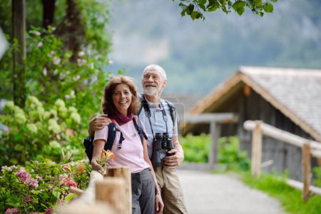 Aktives älteres Ehepaar auf gemeinsamer Fahrt, an einem Frühlingstag. Seniorentouristen zu Besuch und erkunden neue Orte. Sightseeing, Händchenhalten.