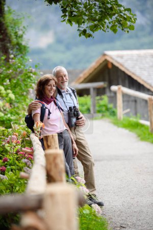 Téléchargez les photos : Couple âgé actif en voyage ensemble, au début de la journée de printemps. Touristes seniors visitant, explorer de nouveaux endroits. Visiter, se tenir la main. - en image libre de droit