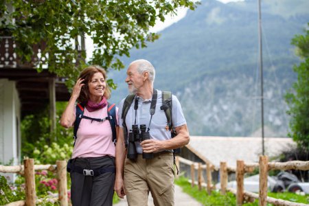 Photo for Active elderly couple on trip together, during early spring day. Senior tourists visiting, exploring new places. Sightseeing, holding hands. - Royalty Free Image