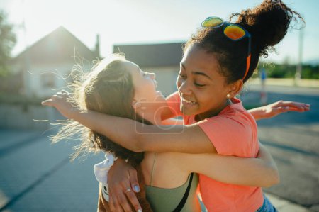 Foto de Joven adolescente mejores amigos saludándose, abrazándose. Las niñas pasan tiempo al aire libre en la ciudad durante el cálido día de vacaciones de verano. - Imagen libre de derechos