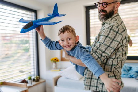 Photo for Playing with lightweight styrofoam planes. Playful father and son throwing and flying foam glider planes. Fathers day and parental love concept. - Royalty Free Image