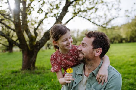 A father looking at daughter lovingly in spring in nature. Fathers day concept.