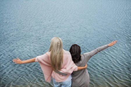 Photo for Adult daughter spending time with her mother. Mom and daughter outdoors, on a walk by reservoir lake, lake embankment. Unconditional, deep maternal love, Mothers Day concept.. - Royalty Free Image