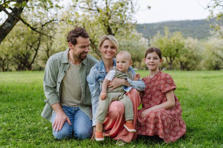 Foto de Retrato familiar con hija y pequeño niño o bebé, al aire libre en la naturaleza de primavera. Familia nuclear. - Imagen libre de derechos