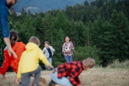 Photo for Young students playing with teacher outdoors, in nature, during field teaching class, having fun. Dedicated teachers during outdoor active education.Teachers Day. - Royalty Free Image