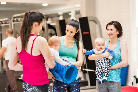 Photo for Group exercise class, mother working out with a baby in gym. Moms staying active while boding with babies. New mom friends. - Royalty Free Image