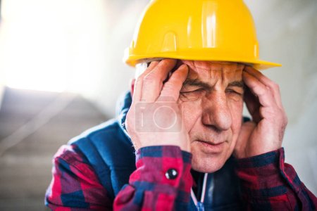 Older worker feeling strong headache. Stroke symptoms. Migraine as severe headache with throbbing, pulsing head pain.