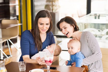 Foto de Nuevos amigos de mamá yendo a la cafetería con bebés. Pasar tiempo libre durante el permiso de maternidad juntos en la ciudad. - Imagen libre de derechos