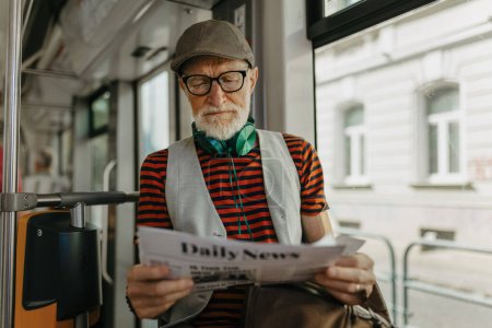 Elderly man traveling through the city by bus, reading a newspaper. Senior city commuter taking tram to grocery store, using public transportation.