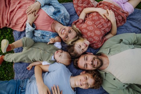 Foto de Vista superior de la familia acostada en el retrato de manta de picnic con dos padres, hijo, hija y pequeño niño al aire libre en la naturaleza de primavera. - Imagen libre de derechos