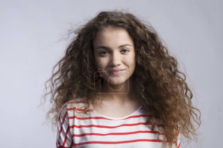 Photo for Portrait of a gorgeous teenage girl with curly hair. Studio shot, white background with copy space. - Royalty Free Image