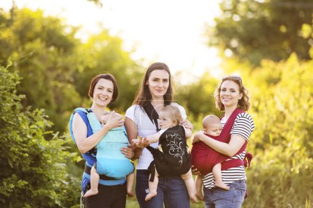 Les mères portant des bébés dans des porte-bébés, des élingues ou des enveloppements. Communauté de portage.