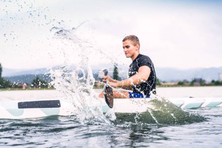 Canoéiste assis en canot pagayant, dans l'eau. Concept de canoë-kayak comme sport dynamique et aventureux. Vue arrière, sportif regardant la surface de l'eau, pagayant.