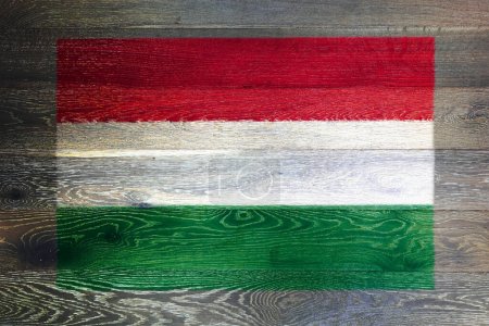 Téléchargez les photos : Un drapeau hongrois sur fond rustique de vieille surface en bois - en image libre de droit
