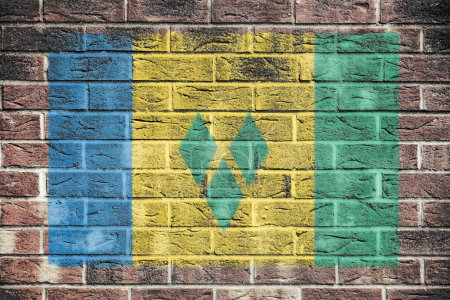 Foto de Bandera de San Vicente y las Granadinas sobre pared de ladrillo viejo fondo azul amarillo verde rayas diamantes - Imagen libre de derechos