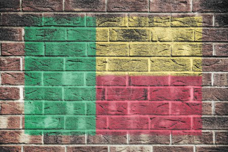 Un drapeau béninois sur fond de mur de briques