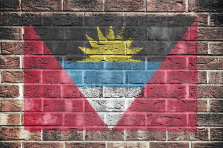 Una bandera de Antigua y Barbuda sobre un fondo de pared de ladrillo