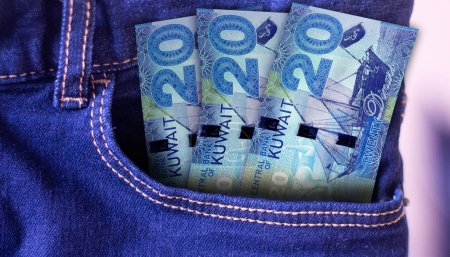 Bunch of 20 Kuwait Dinars banknotes in a jeans pocket a concept of spending