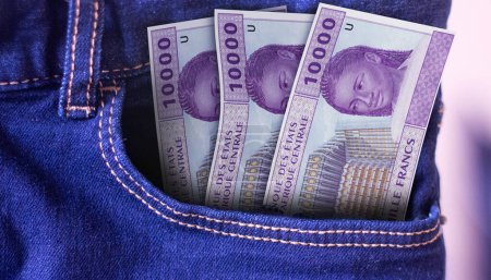 Bunch of 10000 CFA Franc banknotes in a jeans pocket a concept of spending