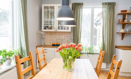 Téléchargez les photos : Tulipes rouges dans un vase sur des fenêtres de table de cuisine en bois - en image libre de droit