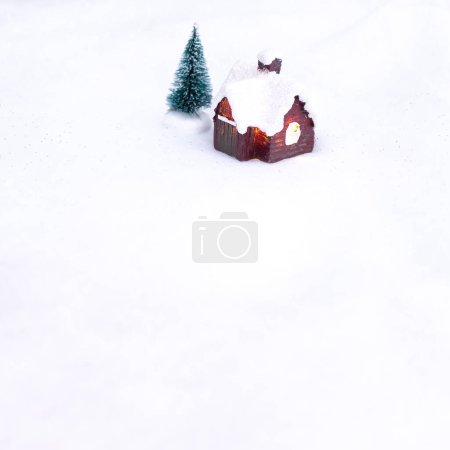 Foto de Fondo de invierno con pequeña casa de campo y árbol de Navidad en el pueblo nevado - Imagen libre de derechos
