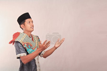 Un hombre musulmán rezando con ambas manos con los ojos mirando hacia arriba con espacio blanco negativo aislado, concepto borroso