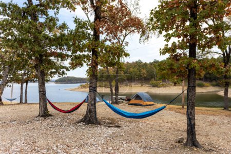 Téléchargez les photos : Camping tentes et hamac près d'un beau lac parmi les arbres, camping, concept de vacances d'aventure, lac Broken bow dans l'Oklahoma, États-Unis. - en image libre de droit