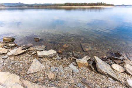 Foto de The shoreline of Broken Bow Lake in Oklahoma, USA. Hermosa vista del lago y las piedras en el costo. - Imagen libre de derechos