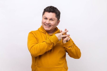 Téléchargez les photos : Viral internet topic. Cheerful man smiling joyfully and showing hashtag gesture, hash symbol of message in social media, wearing urban style hoodie. Indoor studio shot isolated on white background. - en image libre de droit