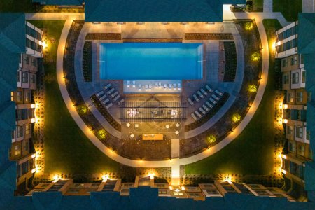 Foto de Vista aérea desde dron de mansiones u hotel con hermosos edificios, vista de la ciudad nocturna con casas residenciales, zona de salón, estacionamiento, piscina. - Imagen libre de derechos