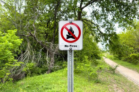 Photo for No fire sign in green garden or park, warning about danger, information about fire prohibition, attention, no fire inscription on whiteboard in forest. - Royalty Free Image