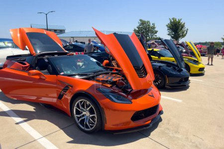 Foto de Little Elm, Texas - 11 de junio de 2023: Chevrolet Corvette naranja y negro con capucha abierta en la feria local de automóviles fuera. - Imagen libre de derechos