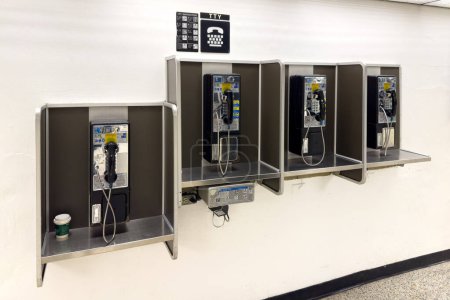 Foto de Miami, Florida - 25 de agosto de 2023: Teléfono público en el Aeropuerto Internacional de Miami. - Imagen libre de derechos
