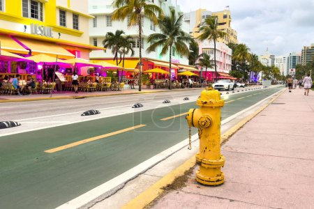 Foto de Miami, Florida - 25 de agosto de 2023: Ocean Drive street. Hidrante de fuego con arquitectura art deco icónica en el fondo. - Imagen libre de derechos
