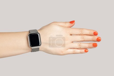 Téléchargez les photos : Gros plan de la main de la femme avec smartwatch avec affichage vide poignée de main avec partenaire. Studio intérieur tourné isolé sur fond gris. - en image libre de droit