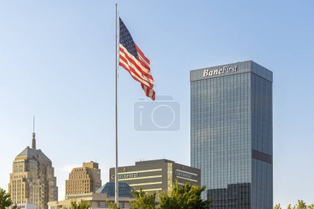 Foto de Oklahoma City, Estados Unidos - 25 de octubre de 2023: Vista de la moderna torre del banco BancFirst y la bandera de Estados Unidos de América. - Imagen libre de derechos