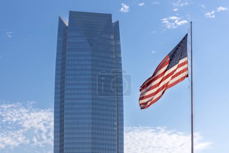 Foto de Oklahoma City, Estados Unidos - 25 de octubre de 2023: Devon Energy Center rascacielos corporativos en el centro de la ciudad y la bandera de Estados Unidos de América. - Imagen libre de derechos